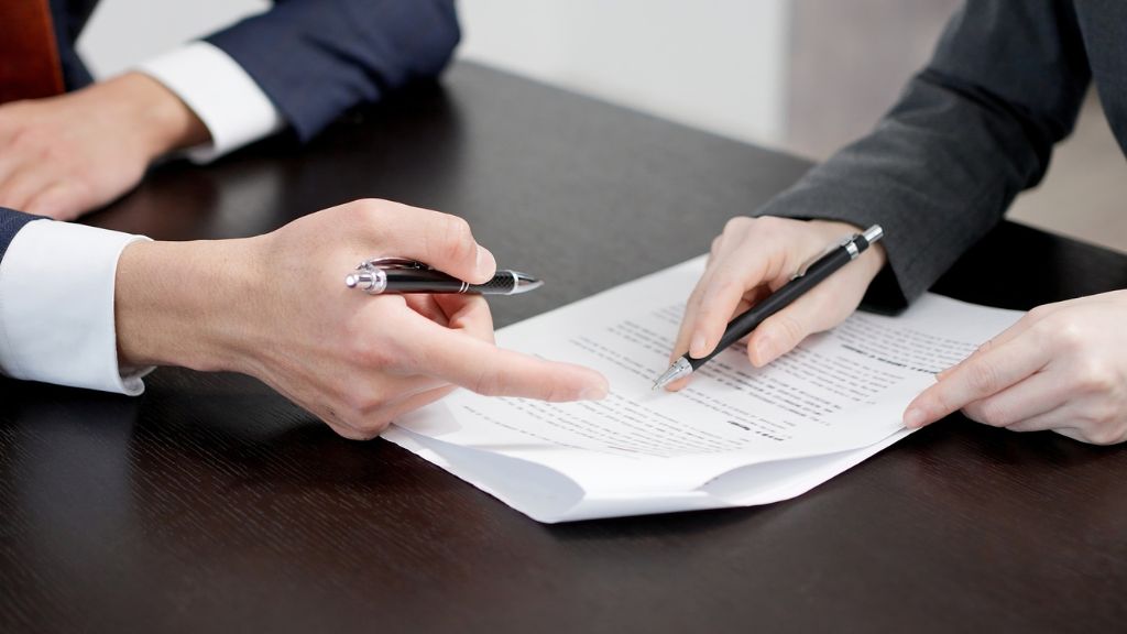 書類をチェックする男女の手元